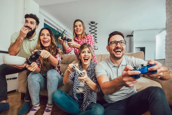Vriendengroep spelen videospelletjes samen thuis, hebben plezier. — Stockfoto