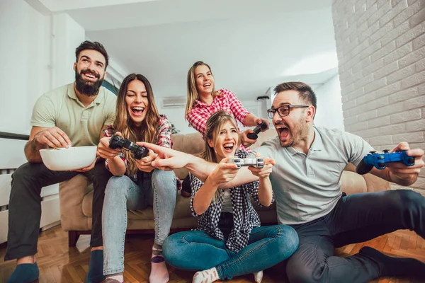 Gruppo di amici giocare ai videogiochi insieme a casa, divertirsi. — Foto Stock