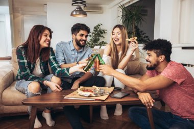Pizza yiyen bir grup genç arkadaş. Ev partisi. Fast food konsepti..