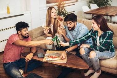 Pizza yiyen bir grup genç arkadaş. Ev partisi. Fast food konsepti..