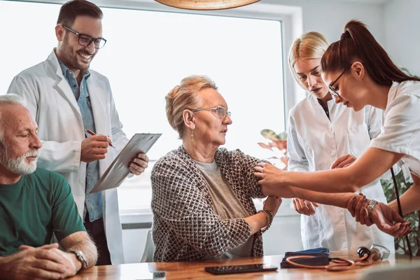 Bild Eines Jungen Sanitäters Der Beim Hausbesuch Blutdruck Nimmt — Stockfoto