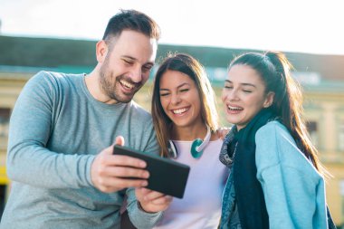 Dijital tablet açık ile gülümseyen arkadaş grubu