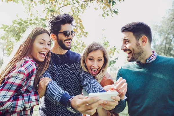 Feliz Sorrindo Jovens Amigos Andando Livre Parque Segurando Telefone Inteligente — Fotografia de Stock