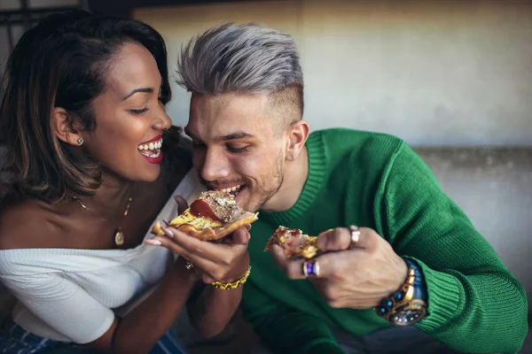 Karışık yarış çift modern kafede pizza yemek. Onlar gülüyor ve pizza yemek ve having a büyük zaman.