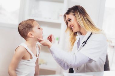 Kadın Doktor muayene çocuk cerrahi, dil depressor ile