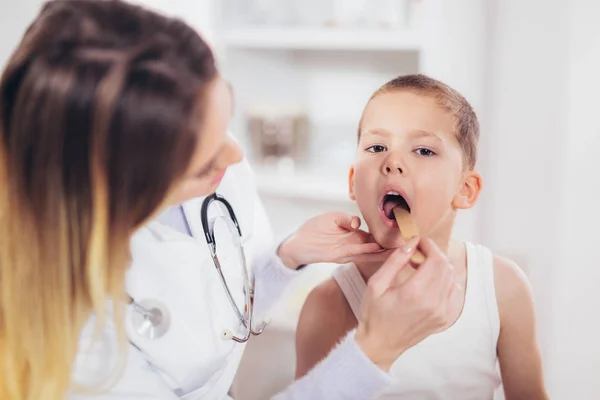 Ärztin Untersucht Kind Mit Zungendepressor Bei Operation — Stockfoto