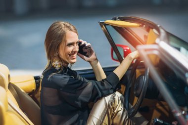 Lüks retro cabriolet oturan ve istimal telefon seksi şık kadın modeli portresi