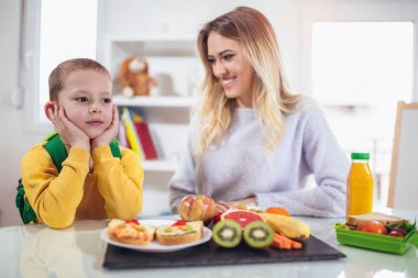 Anne çocuk için Kahvaltı sabah ve aperatif için okul yaptırıyor.