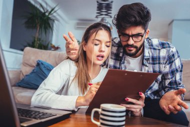 Kadın ve erkek birlikte, ödeme vergi online defter ile evrak işi.