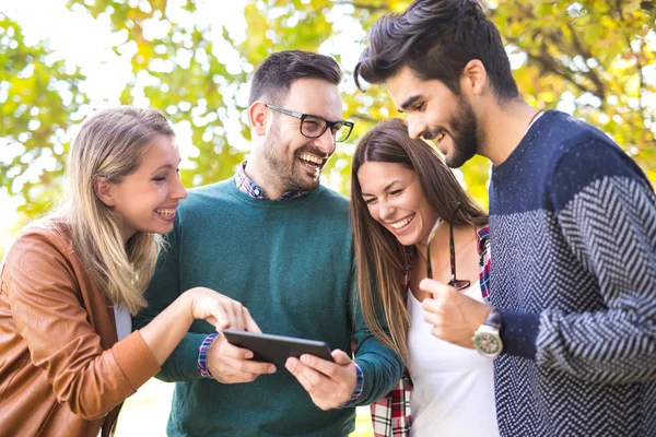 Quatro Jovens Amigos Sorridentes Felizes Andando Livre Parque Usando Tablet — Fotografia de Stock