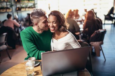 Medya birlikte dizüstü bilgisayarda izlerken kafede oturan genç aşıklar