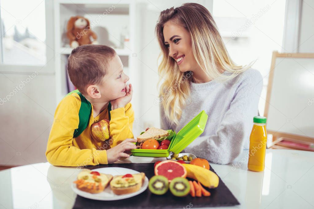 Happy young woman with her son having breakfast