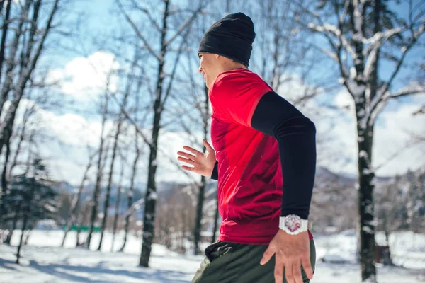 Young man running in winter park — Stock Image Young Man Running Winter Park Stock Photo