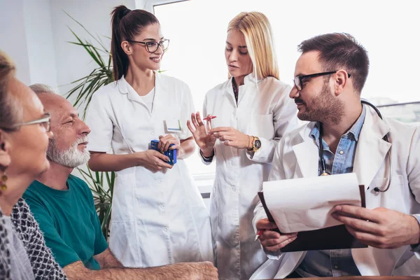 Senior Couple In Discussion With Health Visitor At Home. They talk about prescribed therapy