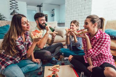 Pizza yiyen bir grup genç arkadaş. Ev partisi. Fast food konsepti..