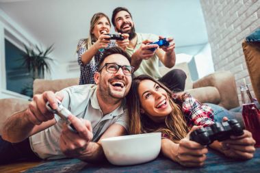 Bir grup arkadaş evde video oyunu oynuyor, eğleniyorlar..