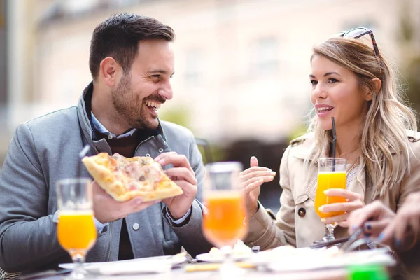 Açık kafede oturan ve pizza yemek güzel sevgi dolu bir çift. Yaşam tarzı kavramı