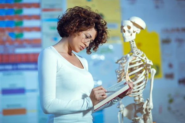 Γυναίκα Ιατρός Διδασκαλία Ανατομία Χρησιμοποιώντας Ανθρώπινο Σκελετό Μοντέλο — Φωτογραφία Αρχείου