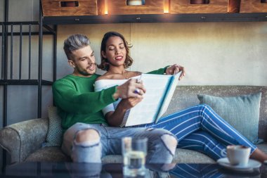 İki mutlu karışık yarış çift kahve dükkanında eğleniyor. Bir kahve dükkanında zevk, masada oturan Çift 