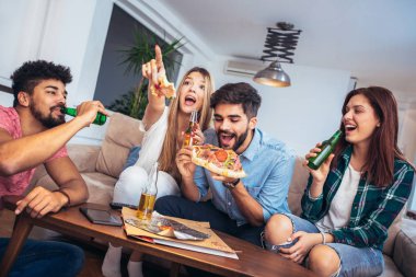 Pizza yiyen bir grup genç arkadaş. Ev partisi. Fast food konsepti..