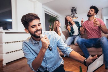 Evde rahatlatıcı arkadaş grubu: karaoke, bira içmek oynarken