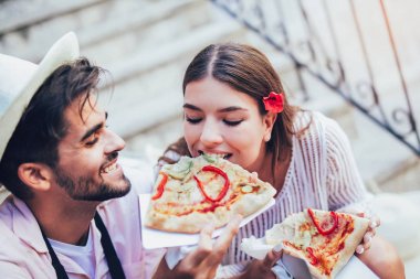 Birkaç turist Caddesi üzerinde pizza yemek