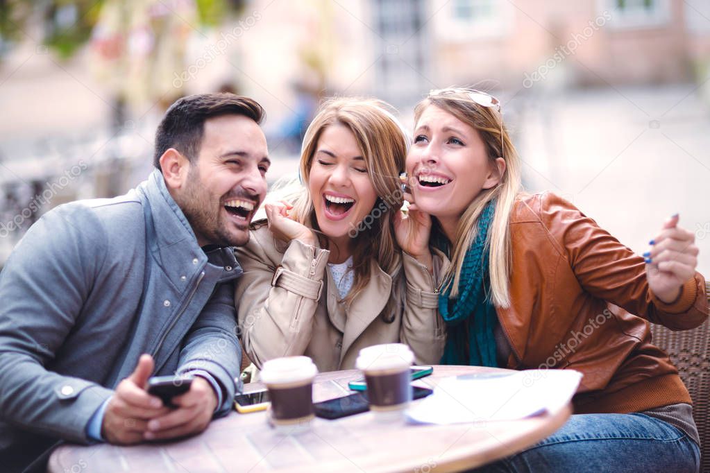 Group of friends laughing with digital tablet outdoor