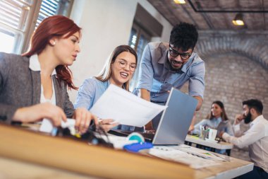 Belgeleri alma ve modern ofiste dizüstü kullanarak grup iş adamları