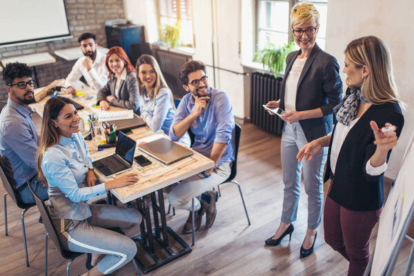 Business smiling colleagues in conference meeting room during presentation