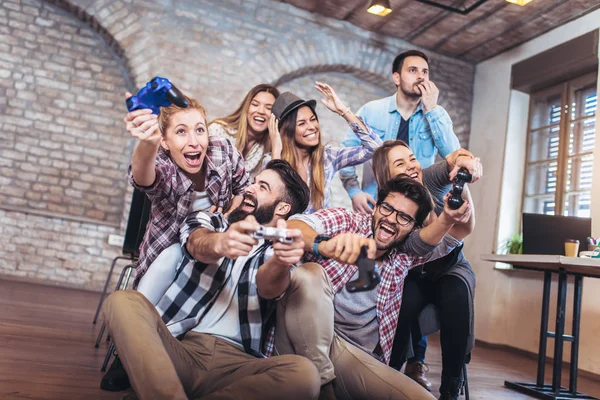 Coworkers playing video games in office.