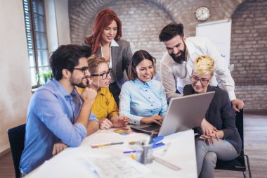 Takım yeni modern ofis projesinde denetlerken dizüstü kullanarak iş adamları