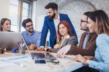 Takım dizüstü bilgisayarlar kullanarak ve yeni modern ofis projesinde çalışan iş adamları