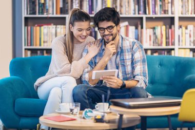 Eğleniyor ve dijital tablet kafede kapalı kullanma genç Çift