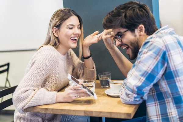 Young Couple Laughing Using Smartphone Cafe — Stock Photo, Image