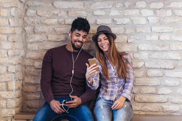 Bir Tuğla Duvar Arka Planda Akıllı Telefon Kullanarak Mutlu Genç — Stok fotoğraf