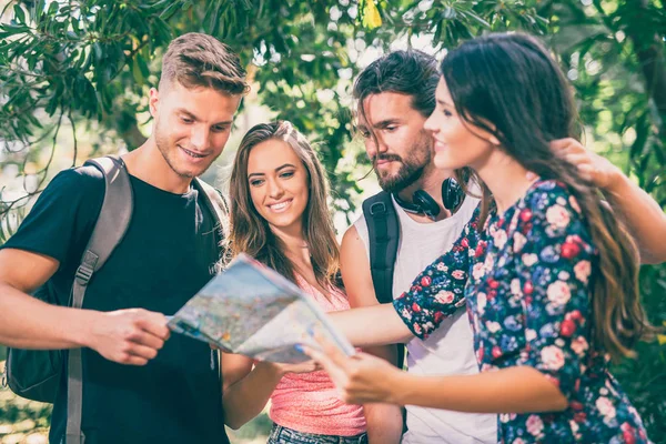 Young people tourists searching for direction using paper map