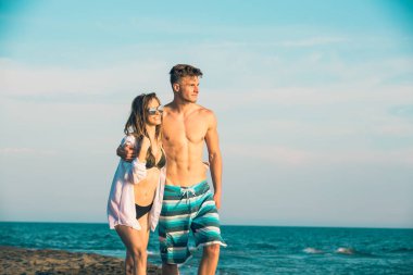 Genç mutlu çift holding birbirlerini etrafında gülümseyen Sahilde yürüyüş.