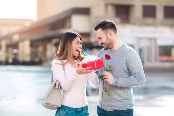 Man Verrassingen Vrouw Met Een Geschenk Roos Stad — Stockfoto