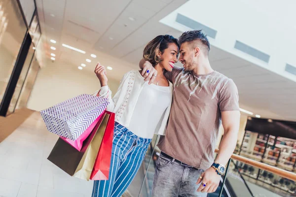 幸せな若いカップルがモールの中を歩いて買い物袋販売 消費者と人々 の概念 — ストック写真