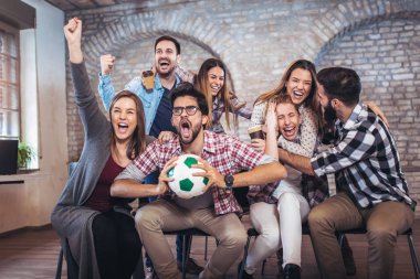 TV'de futbol izlerken ve zaferini kutluyor mutlu arkadaşlar. 