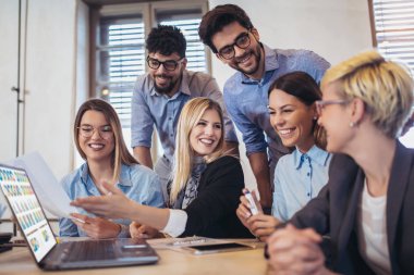  Grup genç iş adamları içinde smart casual giyim birlikte dizüstü kullanarak yaratıcı ofisinde çalışan.