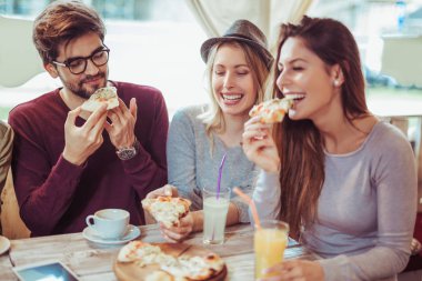 Genç arkadaşlar Cafe pizza paylaşımı