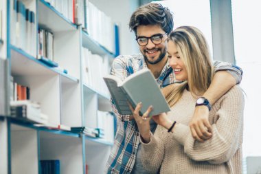 kitaplığındaki kitap ile mutlu öğrenci Çift