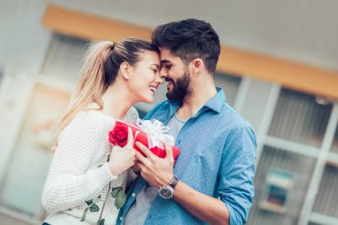 Romantik adam çiçek ve hediye kutusu Sevgililer günü veya yıl dönümü için kadın için veriyor