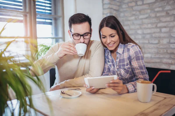 Χαμογελαστά Ζευγάρι Χρησιμοποιώντας Ψηφιακό Tablet Και Πίνει Καφέ Στο Σπίτι — Φωτογραφία Αρχείου