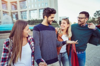 Arkadaş grubu alışveriş torbaları - Satılık, tüketim ve insanlar kavramı ile sokak boyunca yürüyüş