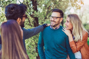Bir grup genç parkta yürüyor. Arkadaşlar dışarıda eğleniyor.