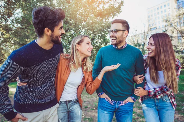 Bir grup genç parkta yürüyor. Arkadaşlar dışarıda eğleniyor.