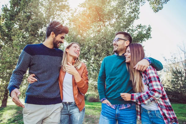 Bir grup genç parkta yürüyor. Arkadaşlar dışarıda eğleniyor.