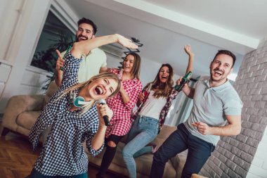 Evde karaoke yapan bir grup arkadaş. Arkadaşlık kavramı, ev eğlencesi ve insanlar